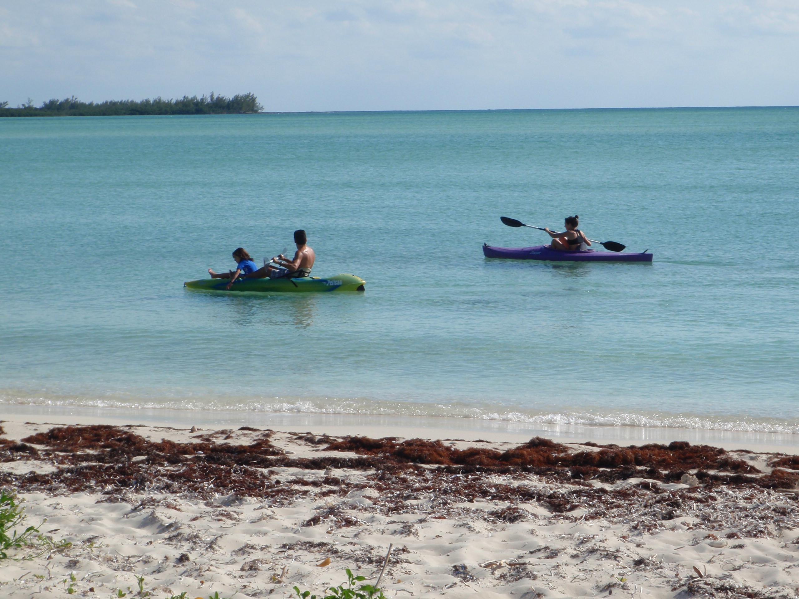 Family kayaking in turquoise water