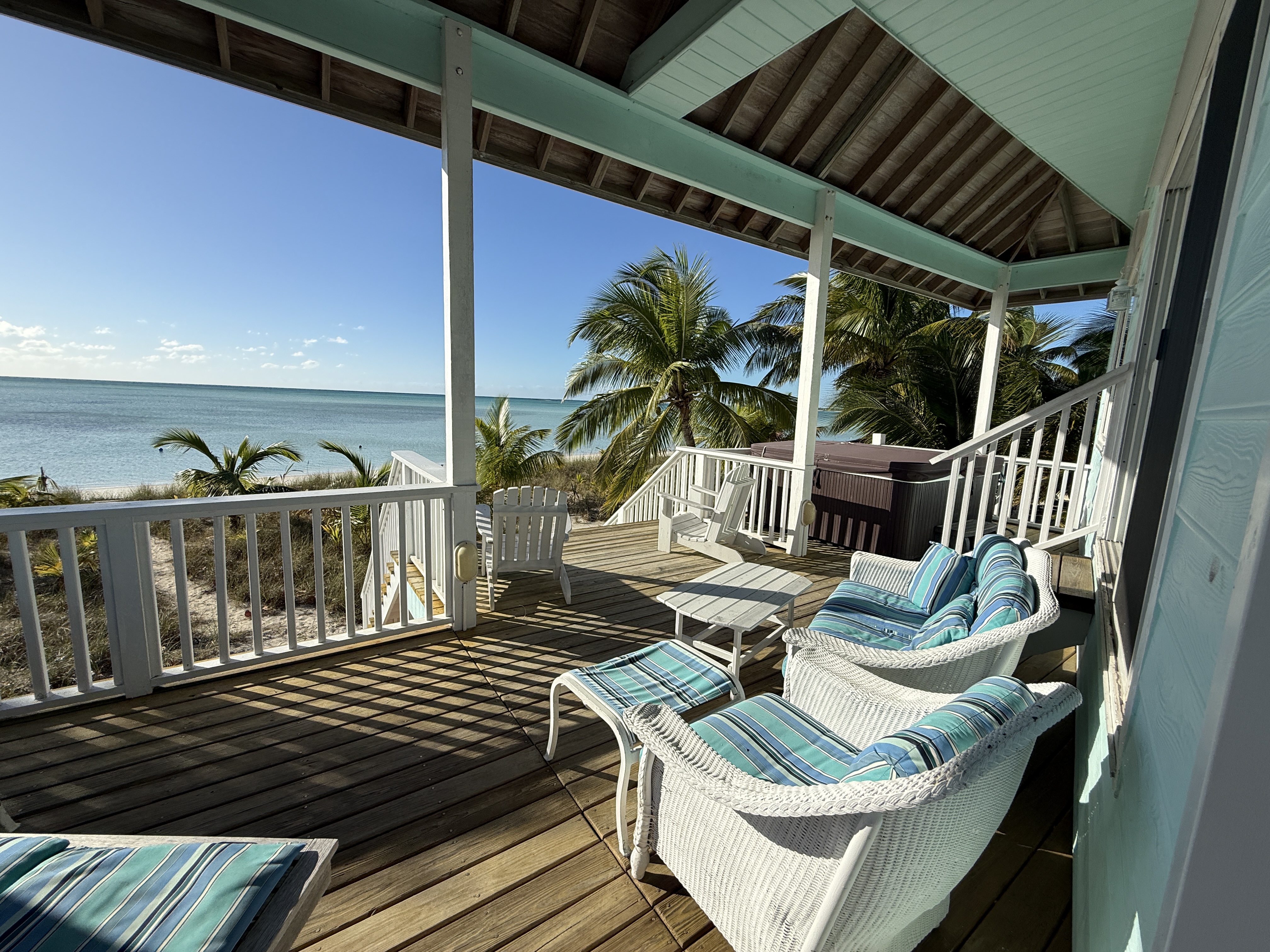 Deck with wicker seating, hot tub and ocean views