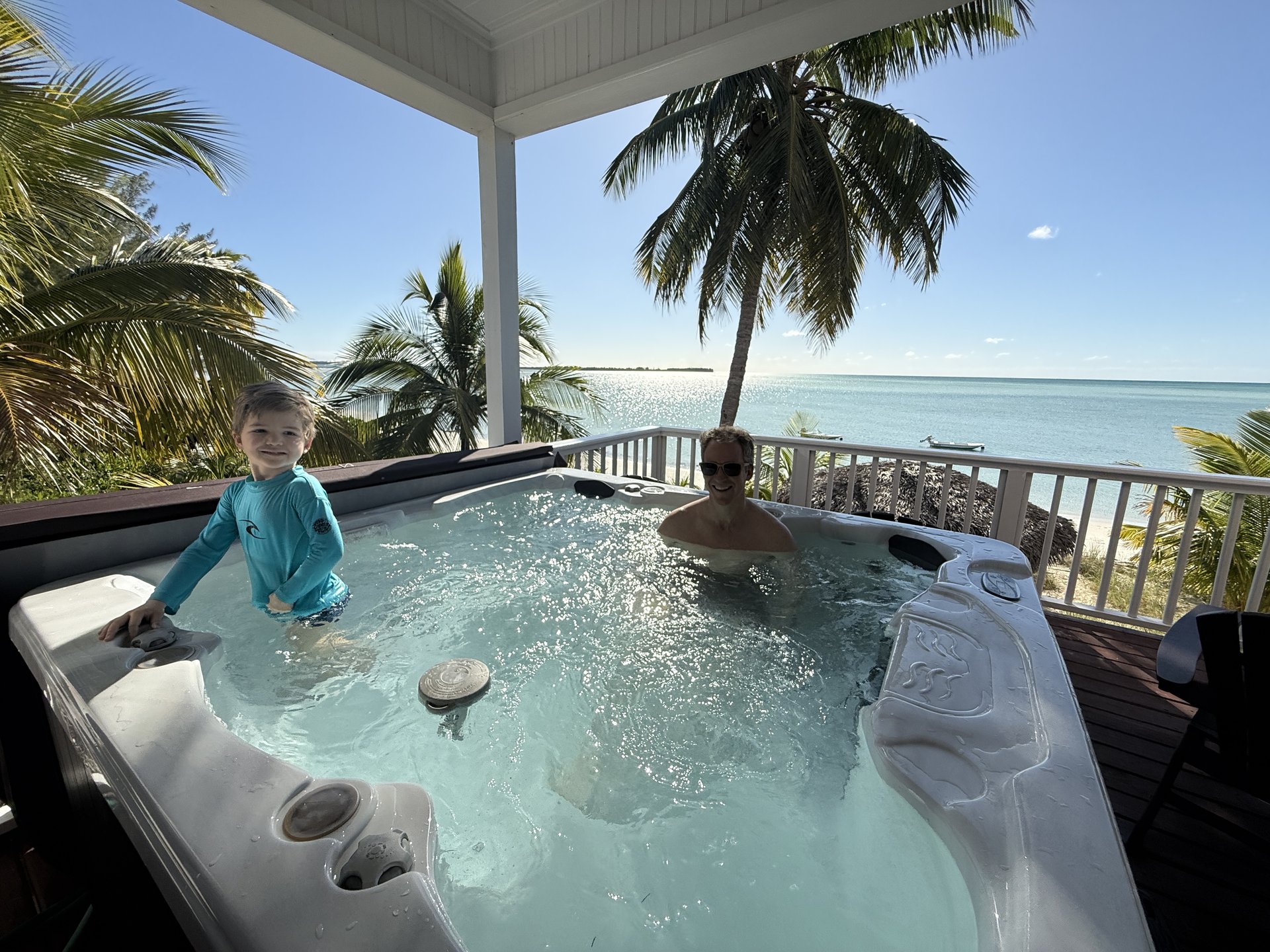 Family enjoying hot tub on deck with ocean panorama