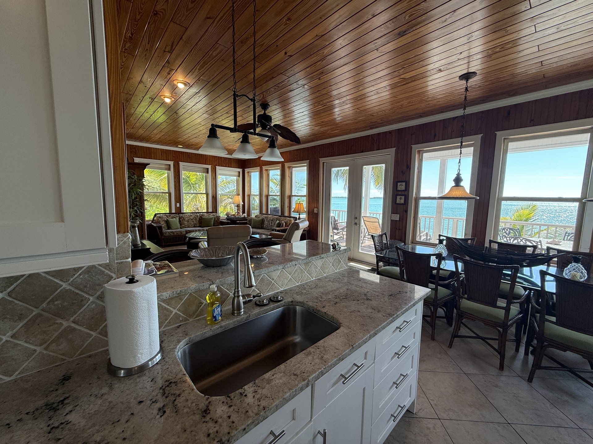 Open great room with kitchen bar, living area and ocean views that make doing dishes a pleasure
