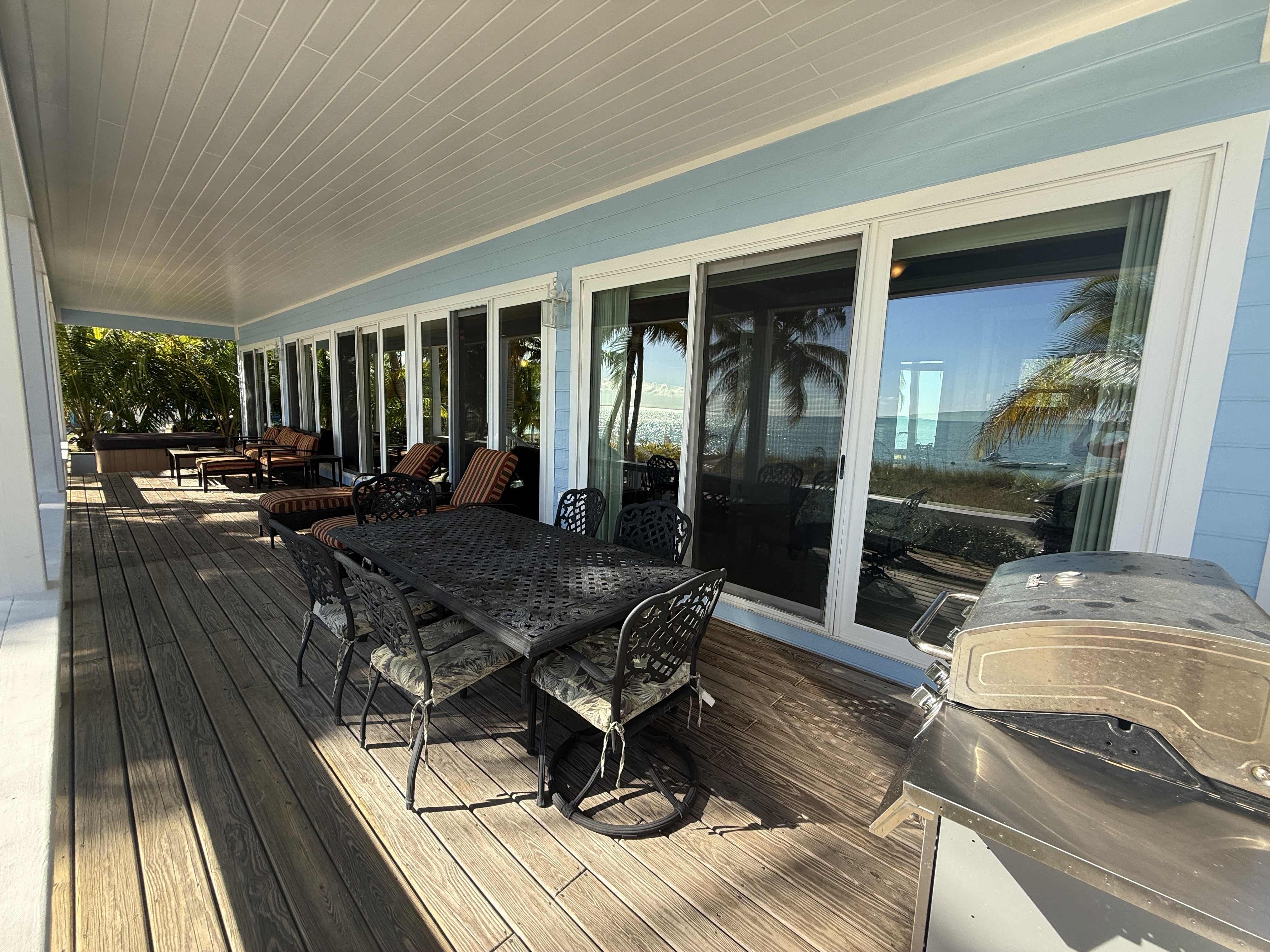 Covered deck with outdoor dining table and ample seating/lounging options