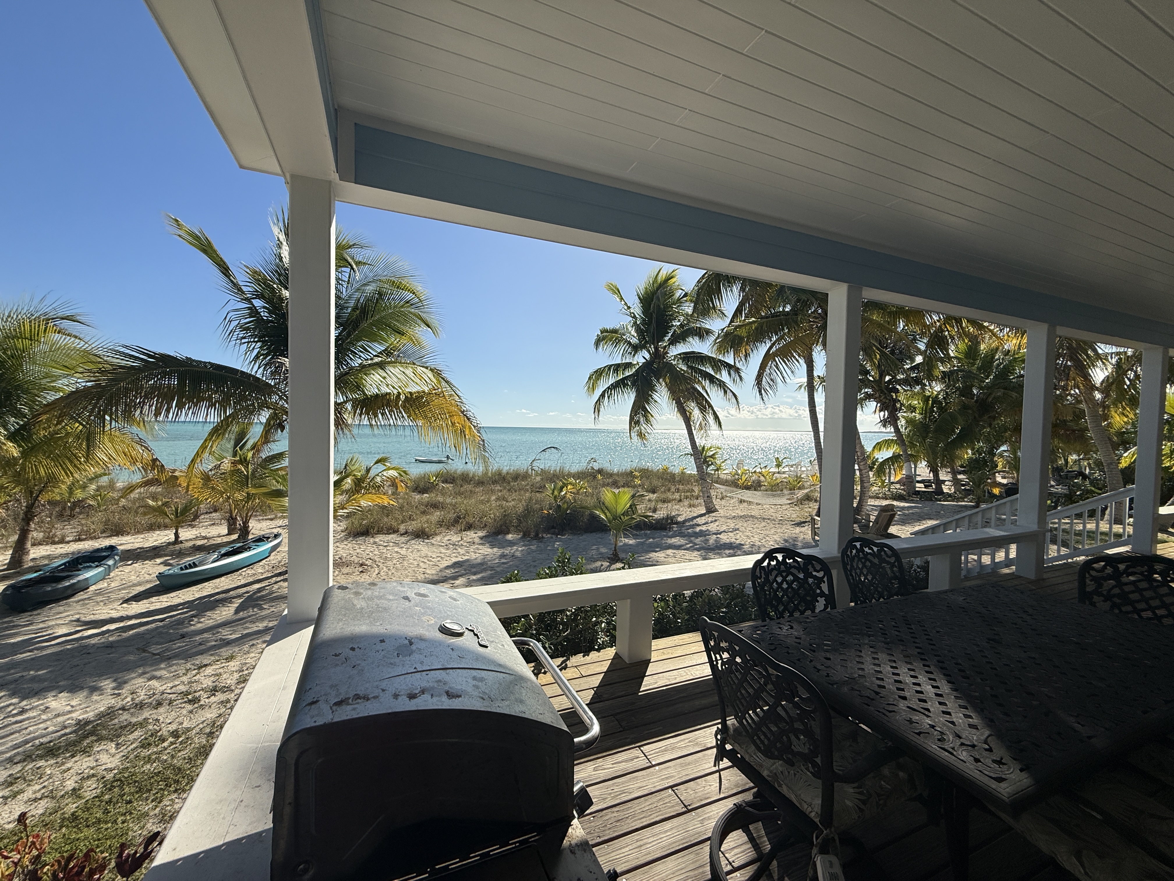 Deck grilling/dining area with kayaks on beach below