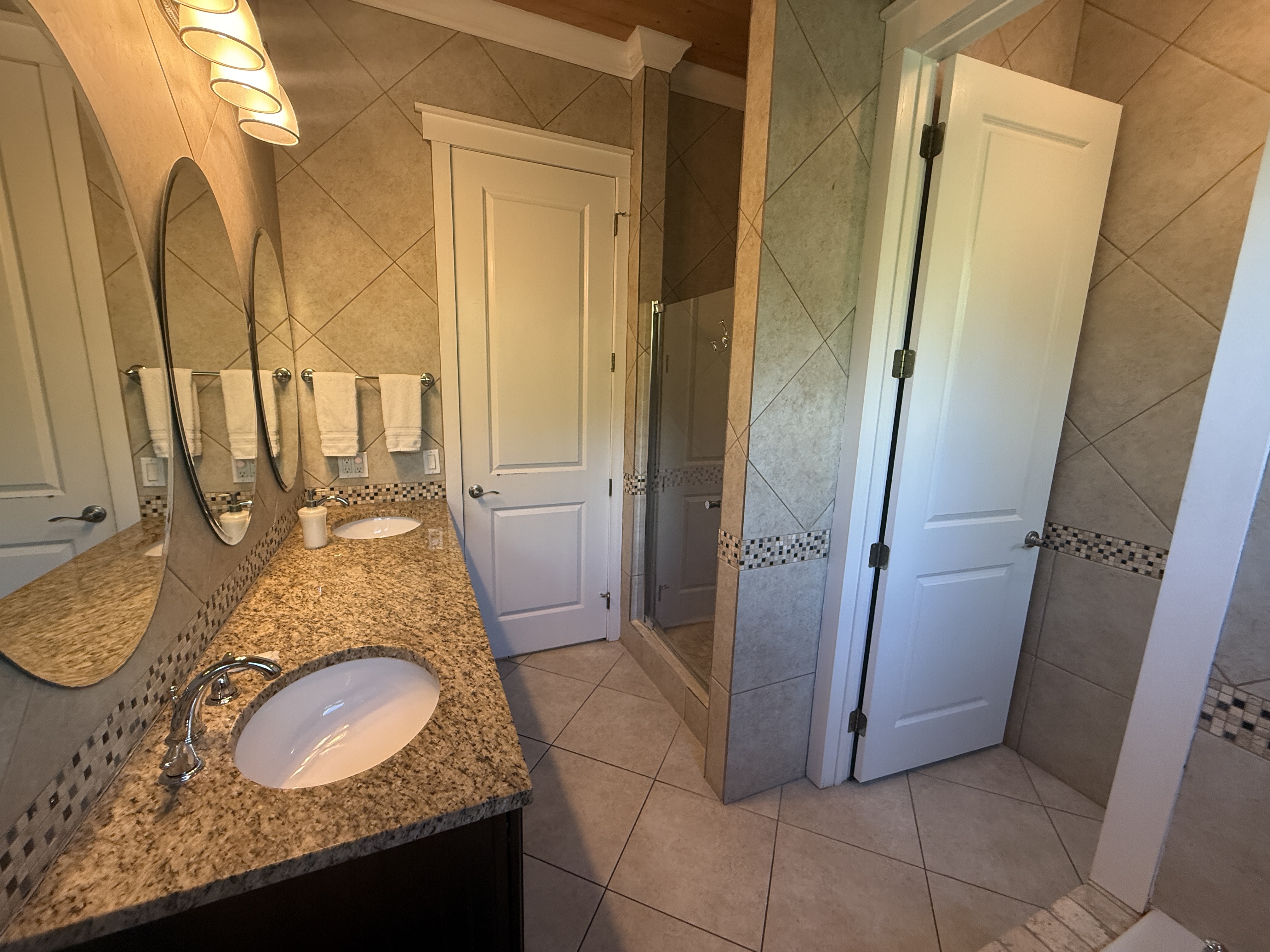 East Master bathroom with double vanity, walk-in shower, and large tub