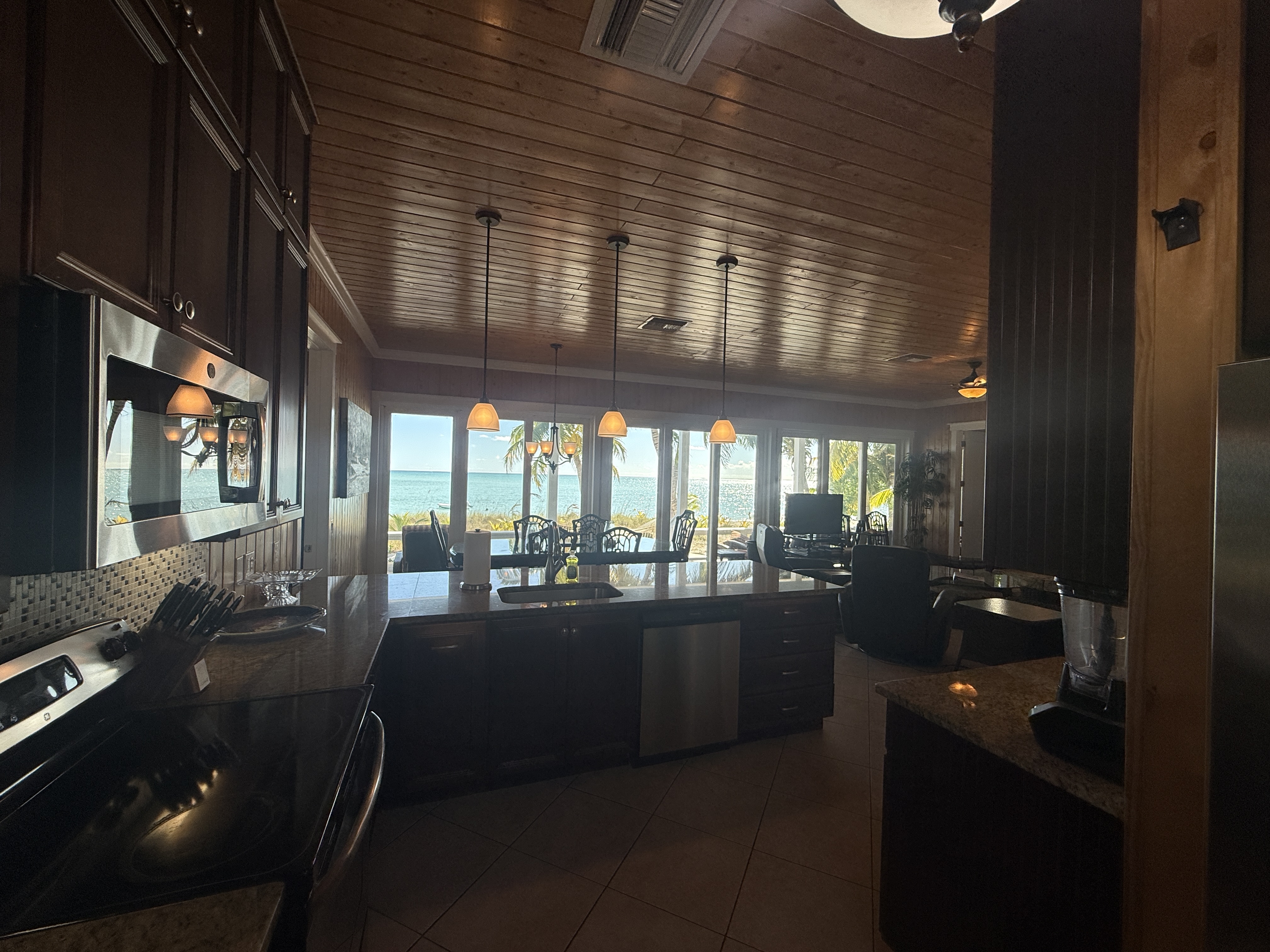 Full kitchen with electric range, large counter, and dining area