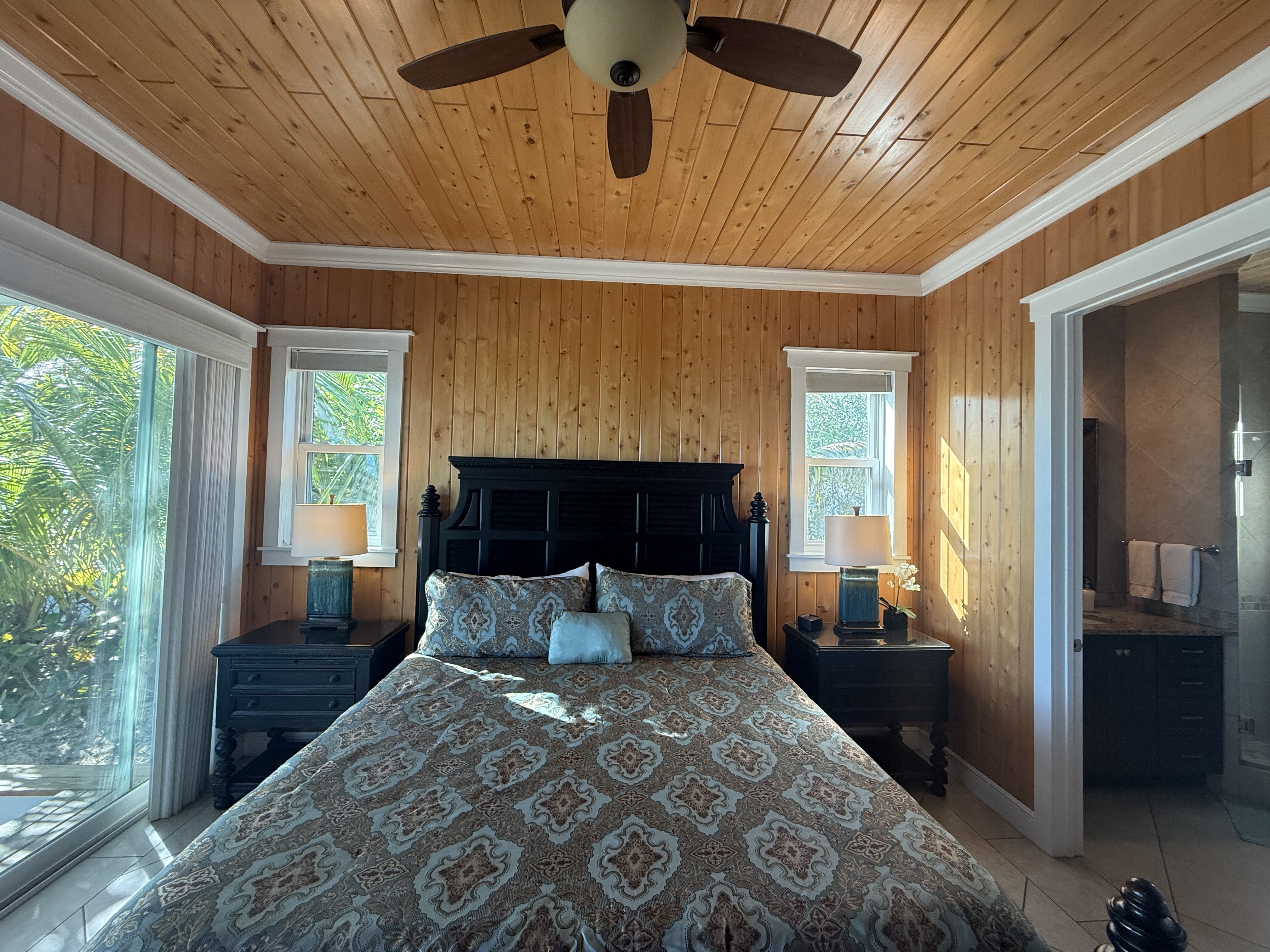 West Master king bed with natural light and tropical views