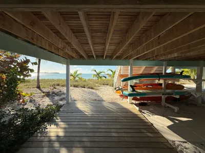 Covered deck for shade and racks with paddle boards and kayaks - under Calypso