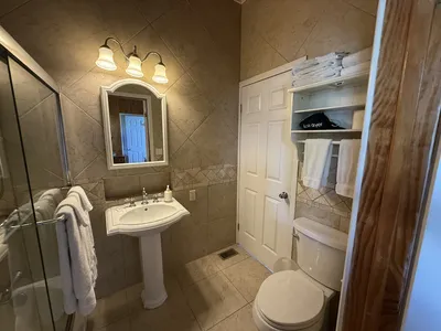 Downstairs Queen Bedroom's en-suite bathroom with pedestal sink and tub/shower