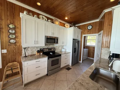 Kitchen with stainless appliances and a high chair when requested