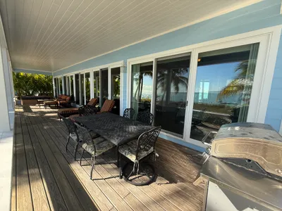 Covered deck with outdoor dining table and ample seating/lounging options