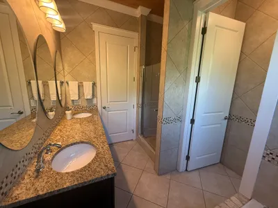 East Master bathroom with double vanity, walk-in shower, and large tub